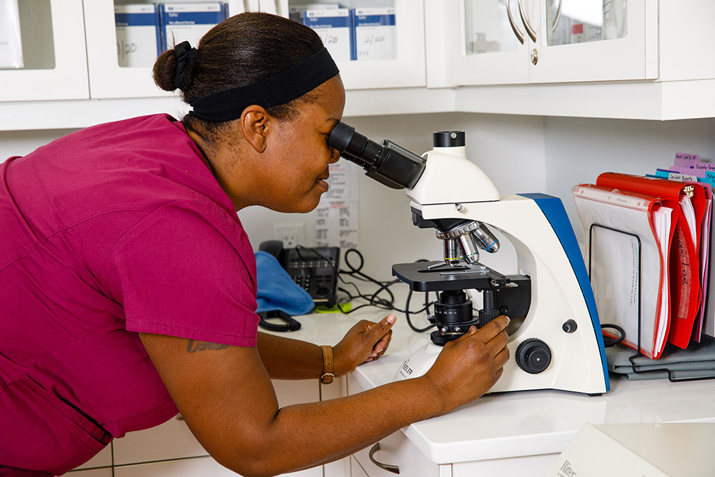 Medical Assistant Laquanda Dixon looking into a microscope
