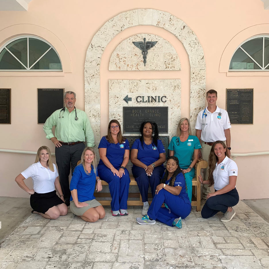 Boca Grande Health Clinic doctors and staff sitting on a Bench donated by the Garden Club