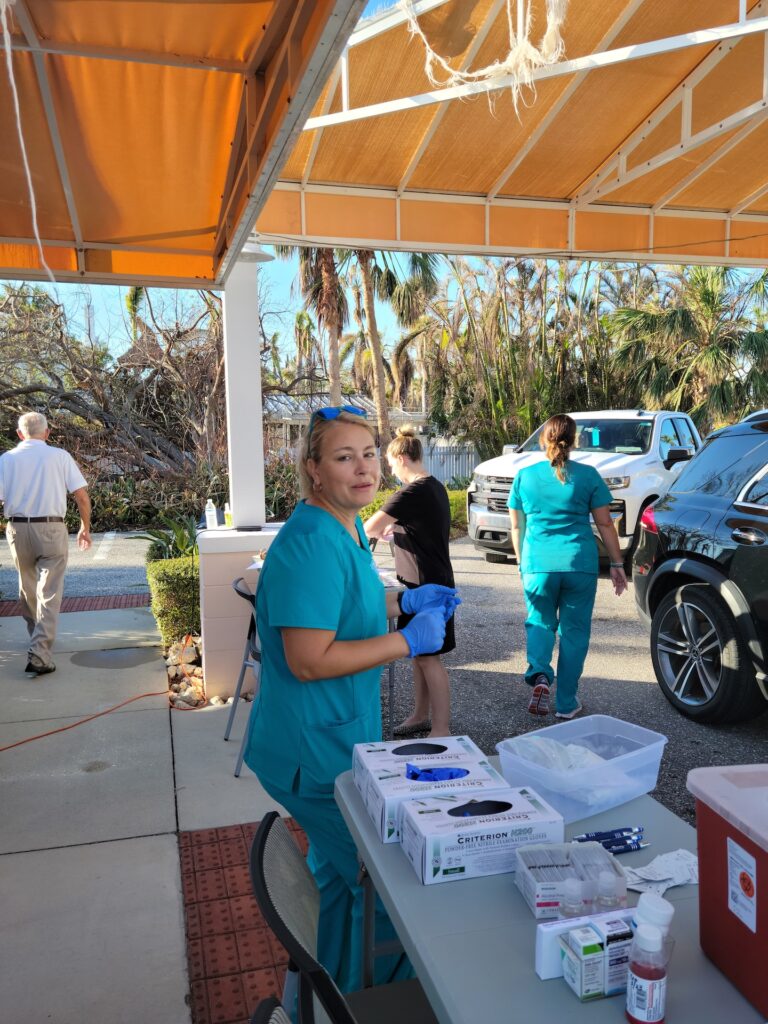 nurse looking at camera in a busy vaccine drive-through