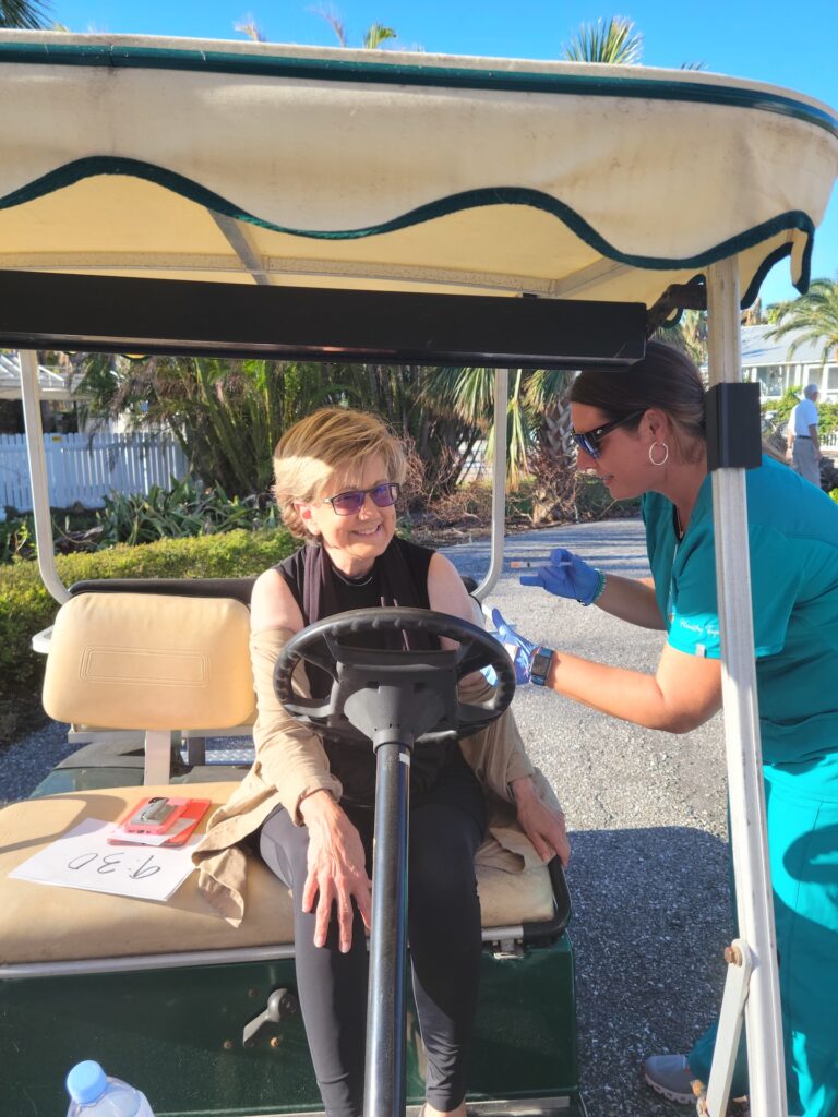 nurse is vaccinating woman in golf cart
