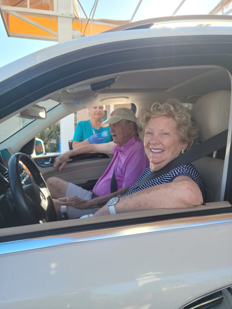 older couple in car, woman smiling from driver seat