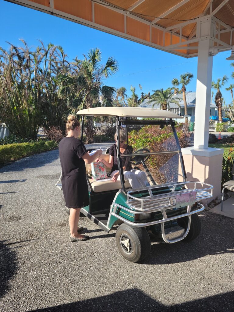 female staff member going over paperwork with woman in golf cart