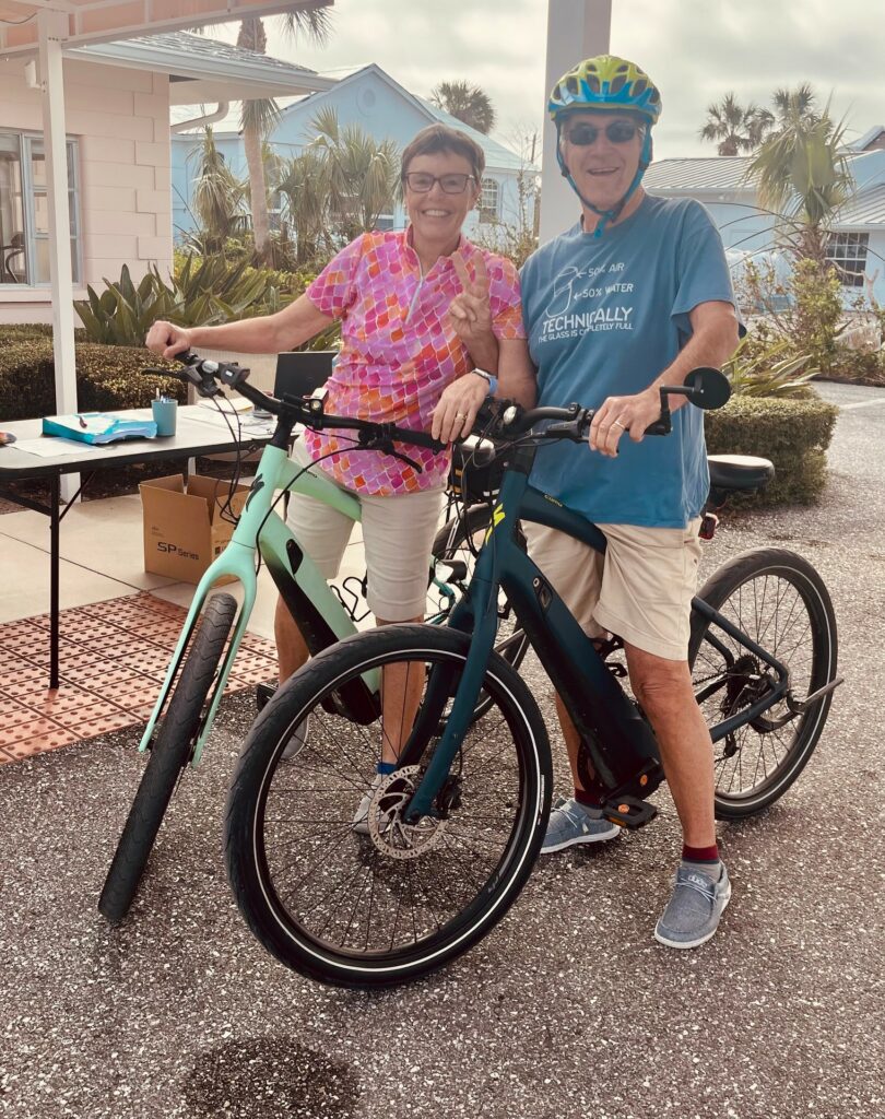man and woman on bicycles at a vaccine drive-through on Boca Grande