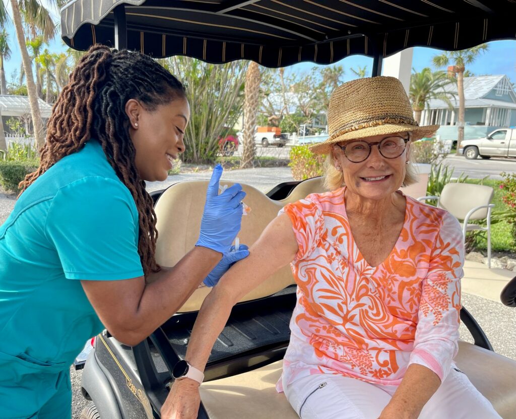 woman sitting in a golf cart getting vaccinated at a vaccine drive-through