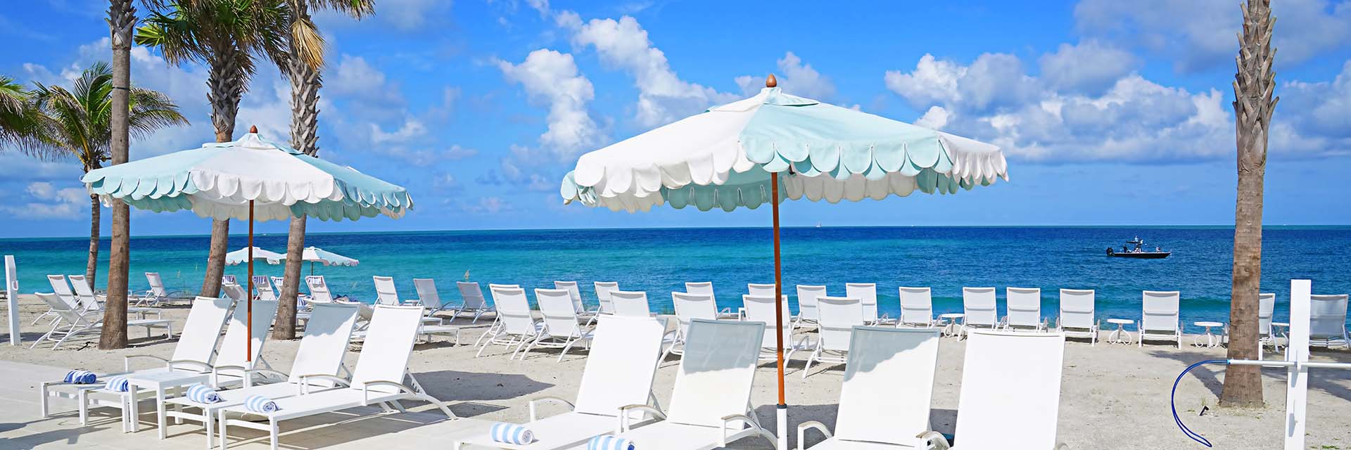 poolside chairs and umbrellas overlooking the ocean at the Gasparilla Inn Beach Club